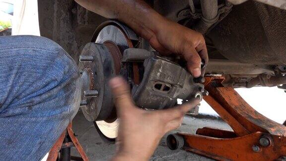 汽车修理工在汽车修理厂修理汽车轮煞车盘