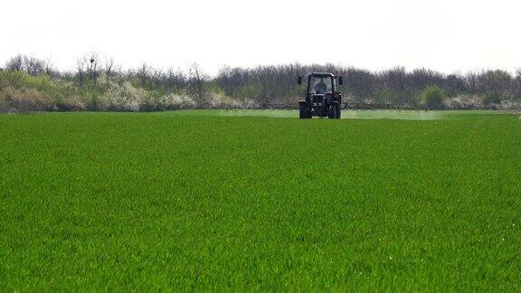 农用拖拉机喷洒绿色麦田
