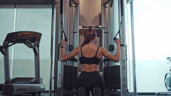 运动的女人在健身房锻炼手臂和肩膀的肌肉健身在健身房锻炼