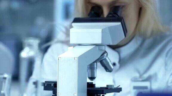 医学研究科学家在显微镜下观察与样本滑动她是一个专业