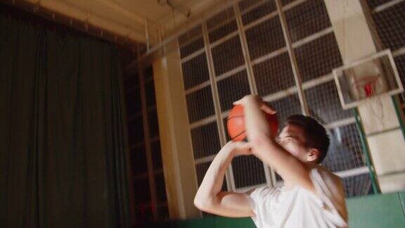 年轻的职业篮球运动员打球把球投进篮里夜晚黑暗剪影后视镜运球近景拼花耐力