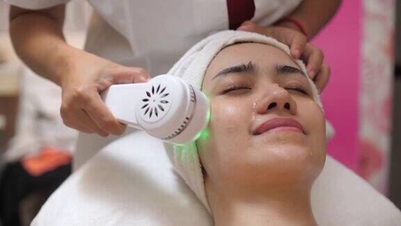 水疗中心面部按摩专业美容师使用离子脸部按摩器