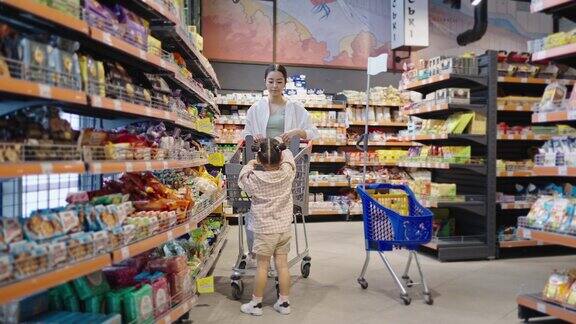 学龄前女孩在超市帮妈妈挑选商品
