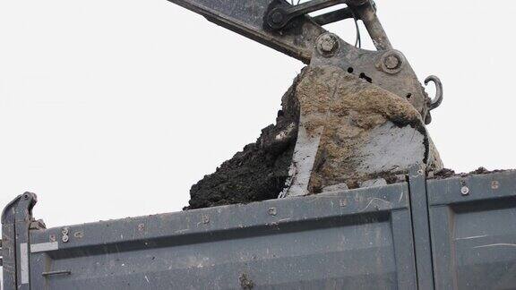 工地上的挖掘机正在工作:拖拉机铲斗正在填满一辆卡车的车身挖掘机和卡车正在装载泥土准备地方建设住宅4k