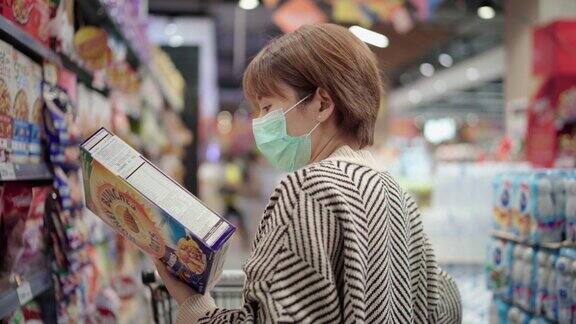 亚洲妇女在杂货店使用污染口罩