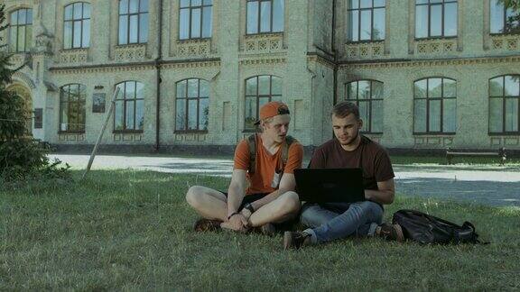 在校园草坪上用笔记本电脑工作的大学生