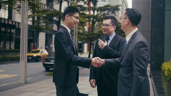 三个亚洲商人在街上交谈