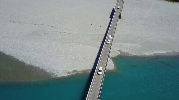 在新西兰南岛西海岸的夏季汽车在横跨蓝色河流的公路桥上超速行驶