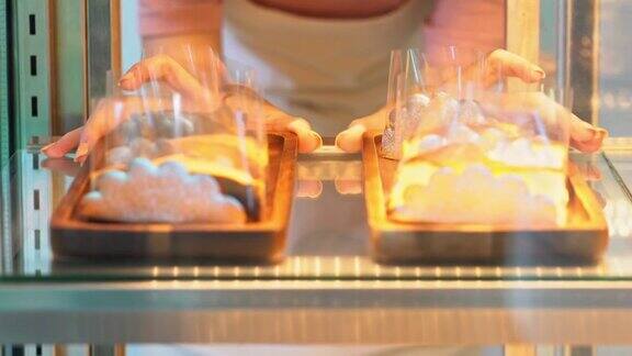 4K亚洲女咖啡店员工把蛋糕放在烘焙冰箱里