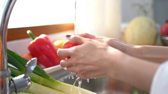 在厨房里洗水果或蔬菜的女人