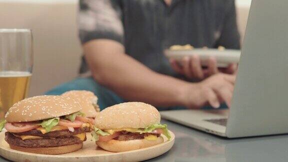 桌上汉堡的4k视频大胖子吃薯条的背景不健康的生活方式观念