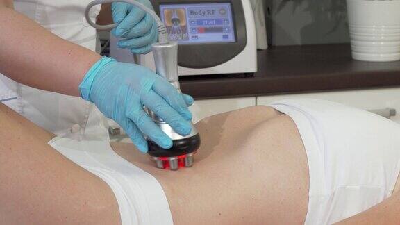 裁剪镜头的一个女性客户接受rf提升治疗在她的胃
