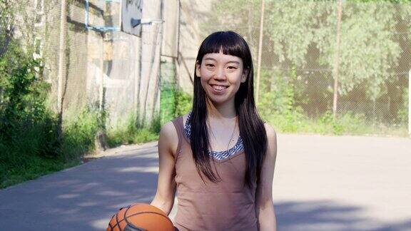 微笑的女篮球运动员站在球场上