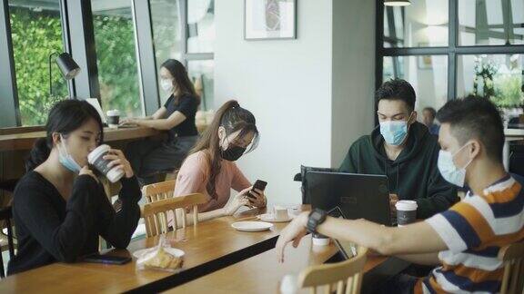 亚洲华人在咖啡馆享受食物和放松周末与新常态戴口罩