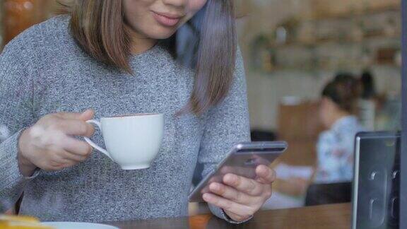 女人使用手机和放松在咖啡馆摄影