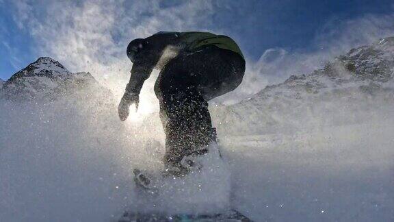 SLOMO自由式滑板滑雪运动员从积雪覆盖的斜坡上滑下