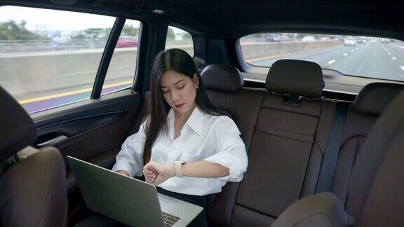 晚上坐在出租车后座上的女商人女人在笔记本电脑上工作
