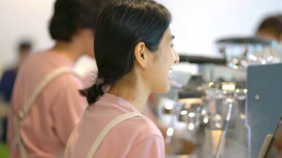 4K亚洲女咖啡店员工在接顾客的订单