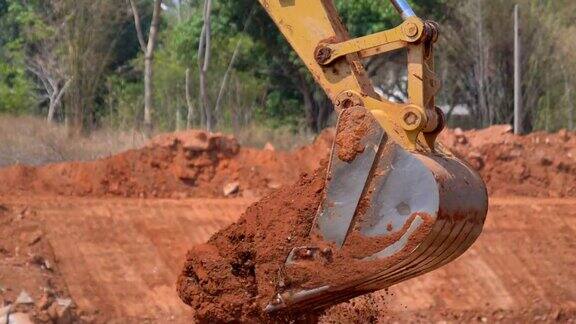 图为挖掘机铲斗在阳光明媚的施工现场挖土