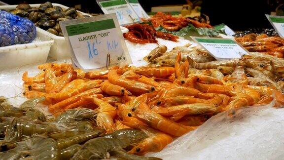 在LaBoqueria鱼市的柜台上冰里的红色小龙虾和虾巴塞罗那西班牙