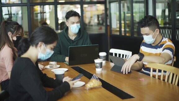 亚洲华人在咖啡馆享受食物和放松周末与新常态戴口罩