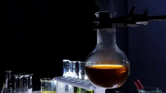 近距离酒精灯是煮沸的化学液体颜色烧瓶与实验室玻璃器皿在黑色背景实验室研发
