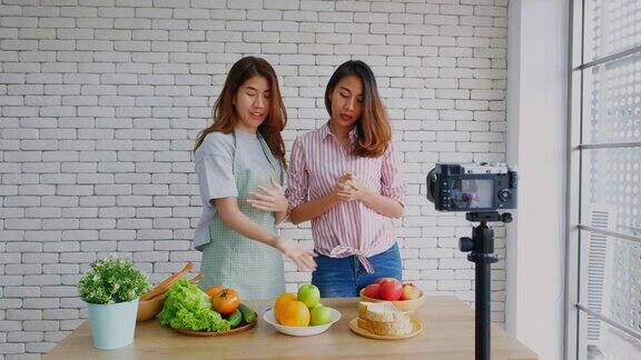 两个年轻的亚洲女性美食博客解释健康的食物和健康的生活方式同时录制视频播放Vlog健康的生活方式