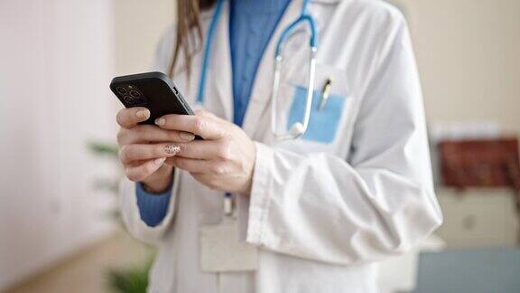年轻的白人女医生在诊所使用智能手机