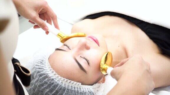 亚洲妇女得到金勺医疗美容设备在美容诊所改善皮肤光滑和治疗痤疮的医学治疗