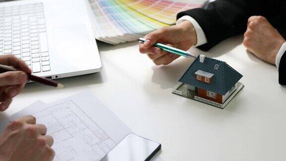 建筑师在办公室向客户展示新的家庭住宅模型