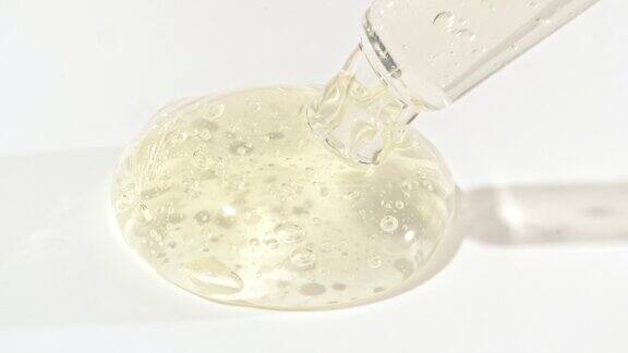液体液体黄色凝胶或血清滴在白色表面上面有气泡的化妆液滴管
