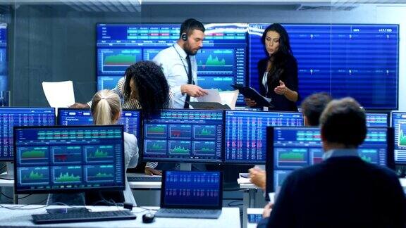 多民族团队在证券交易所办公室忙碌工作交易者和经纪人在市场上买卖股票显示器显示相关的信息图数据和数字