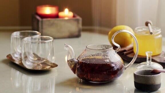 茶壶与热蒸红茶桌上盖蜂蜜和柠檬
