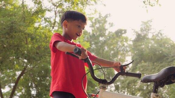 两个亚洲男孩在公园里愉快地骑着自行车