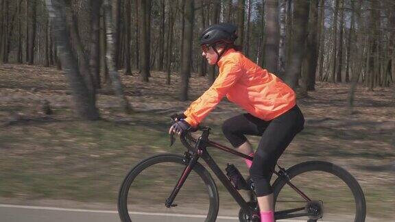 戴头盔的妇女正在骑公路自行车女性骑自行车女孩骑自行车铁人三项