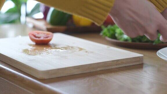用锋利的刀在木板上切西红柿的特写镜头