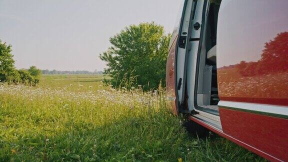 一辆DL露营车停在春暖花开的草地上