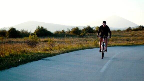 一个年轻人在乡间小路上骑自行车
