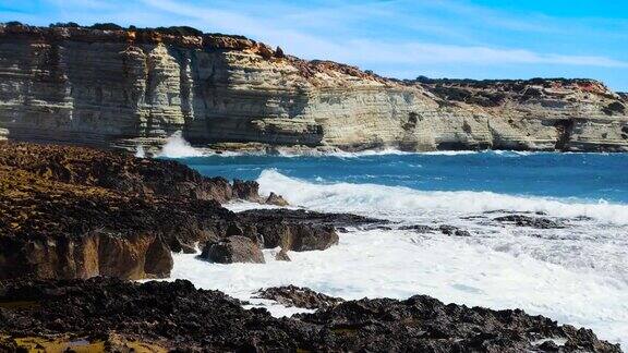 阳光明媚的白天海景毁灭性和壮观的海风暴海浪撞击海岸的岩石创造了水的爆炸