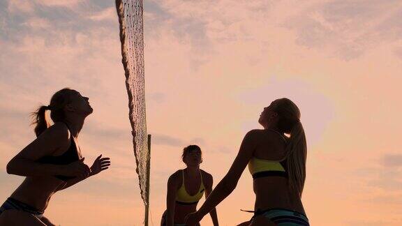 一群年轻女孩在日落或日出时打沙滩排球慢镜头