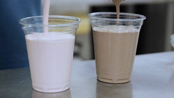 奶昔美味的甜点饮料巧克力奶昔倒入玻璃杯草莓奶昔倒入冰淇淋和牛奶草莓奶昔倒入塑料杯