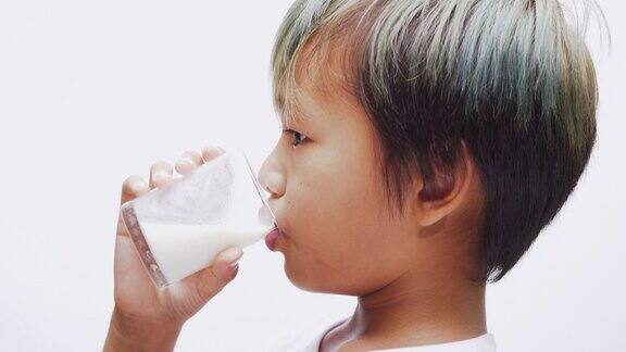 亚洲男孩肖像喝牛奶的杯子在手里美味健康牛奶