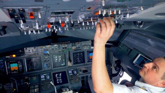 飞行员在飞行前正在切换驾驶舱上方的按钮