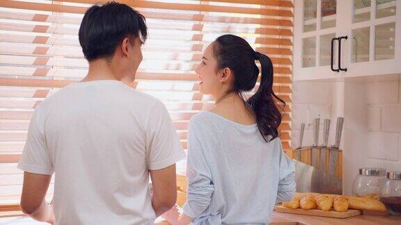 亚洲年轻的新婚夫妇在家里的厨房共度时光有魅力的男人和女人感到快乐和放松享受美食的早餐与幸福家庭关系概念