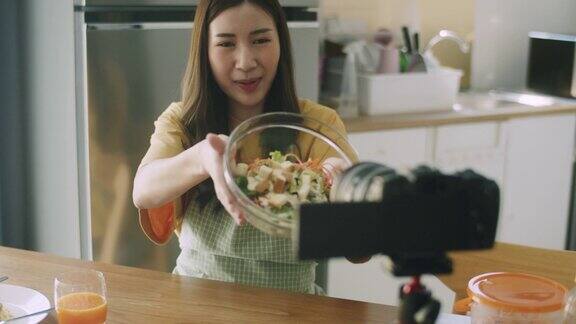 年轻的女性有影响力的美食博主在家里的厨房拍摄视频教程社交媒体影响者