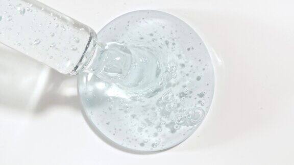 液体液体蓝色凝胶或血清滴在白色表面化妆液滴管上面有气泡