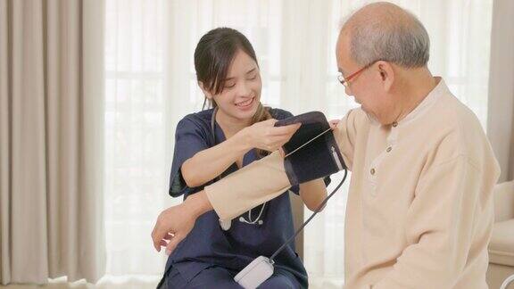 老年人高血压在家庭护理访问期间一名女医生使用数字医用眼压计检查一名老年成年患者一位心脏病专家给一位老人做检查