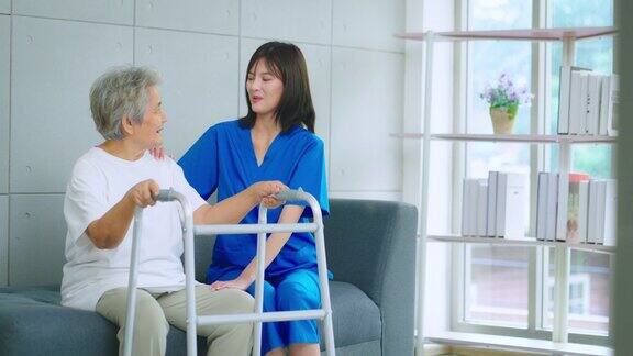 护士在医院照顾一位用助行器走路的老妇人