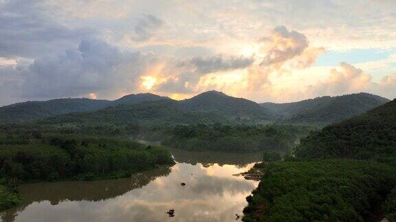 泰国松卡省迦那区里黄村湖、山、松树的无人机日出景观