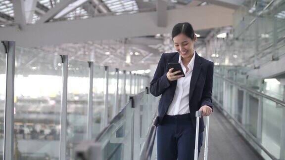 商务女性在机场和商务旅行中使用智能手机